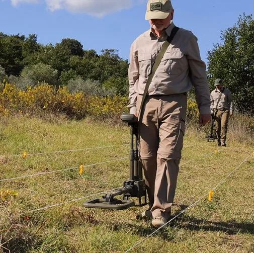 A searcher surveying a marked field lane with a CEIA DSMD