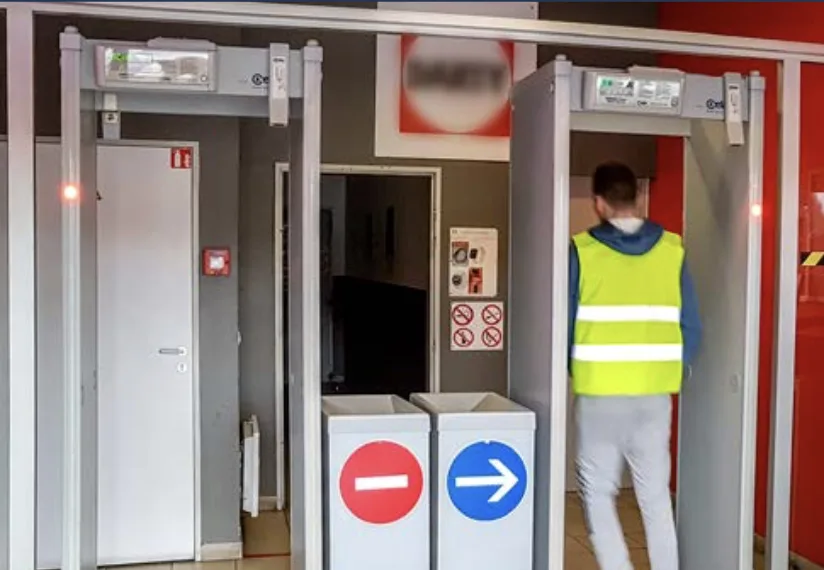 A member of staff walking through CEIA walk-through detectors at a site exit